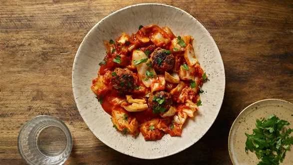 Młoda kapusta duszona z kminkiem, pomidorami i klopsikami